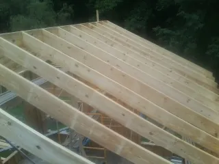New roof rafters set over an addition before sheathing in Dunbar