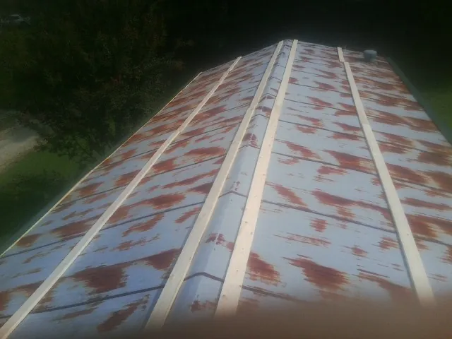 Rusted metal roof panels with new wood purlins before replacement — Storm Damage Roof Repair in Dunbar by Roofing Brothers
