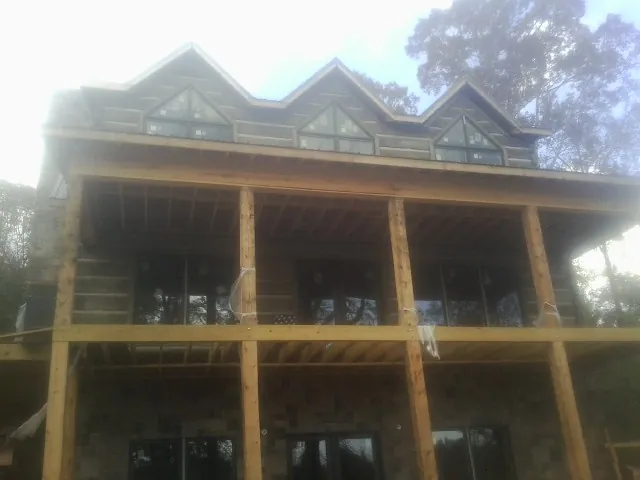 Dormers and porch framing on a large log home under construction — Roof Coating work by our crew in Dunbar